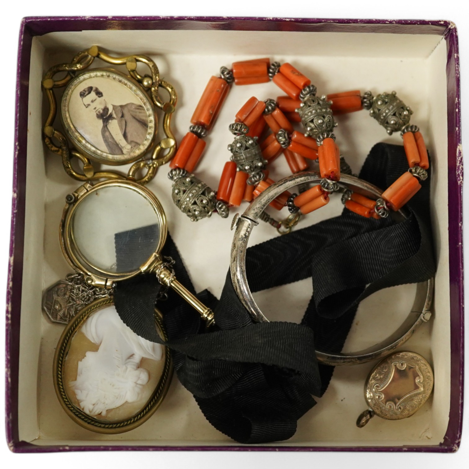 A small collection of mainly antique jewellery including coral beads, pair of lorgnettes, a gold plated oval locket etc. Condition - poor to fair